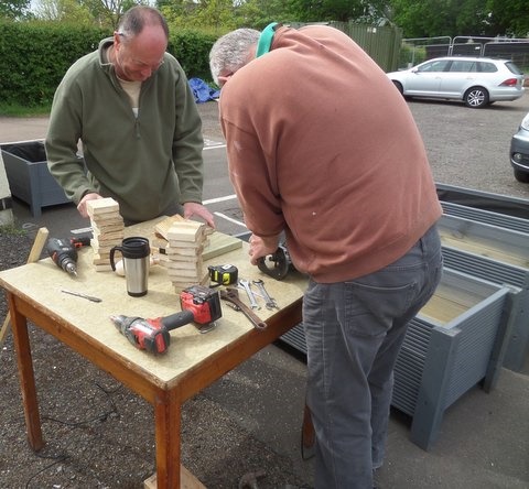 2 members of men in sheds manufacturing end caps to go on the corners of Planters
